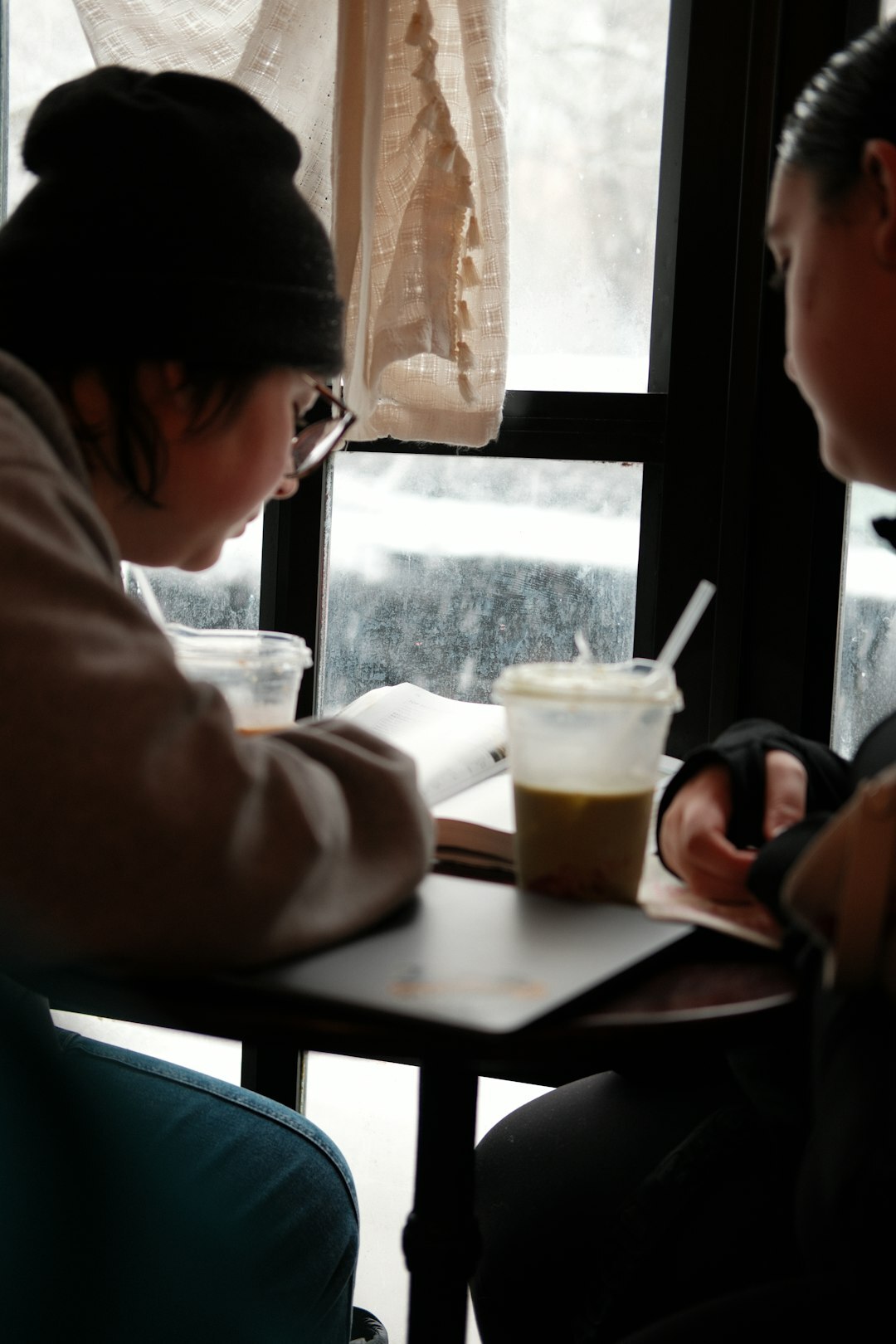 person reading book by window